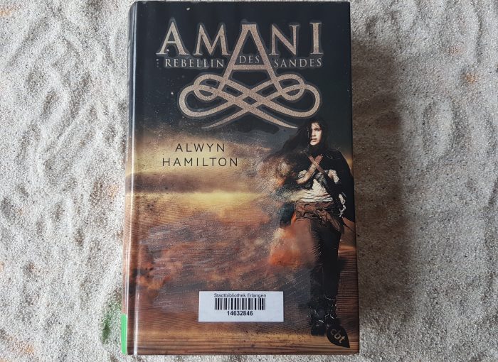 Das Buch "Amani - Rebellin des Sandes" liegt im Sand.