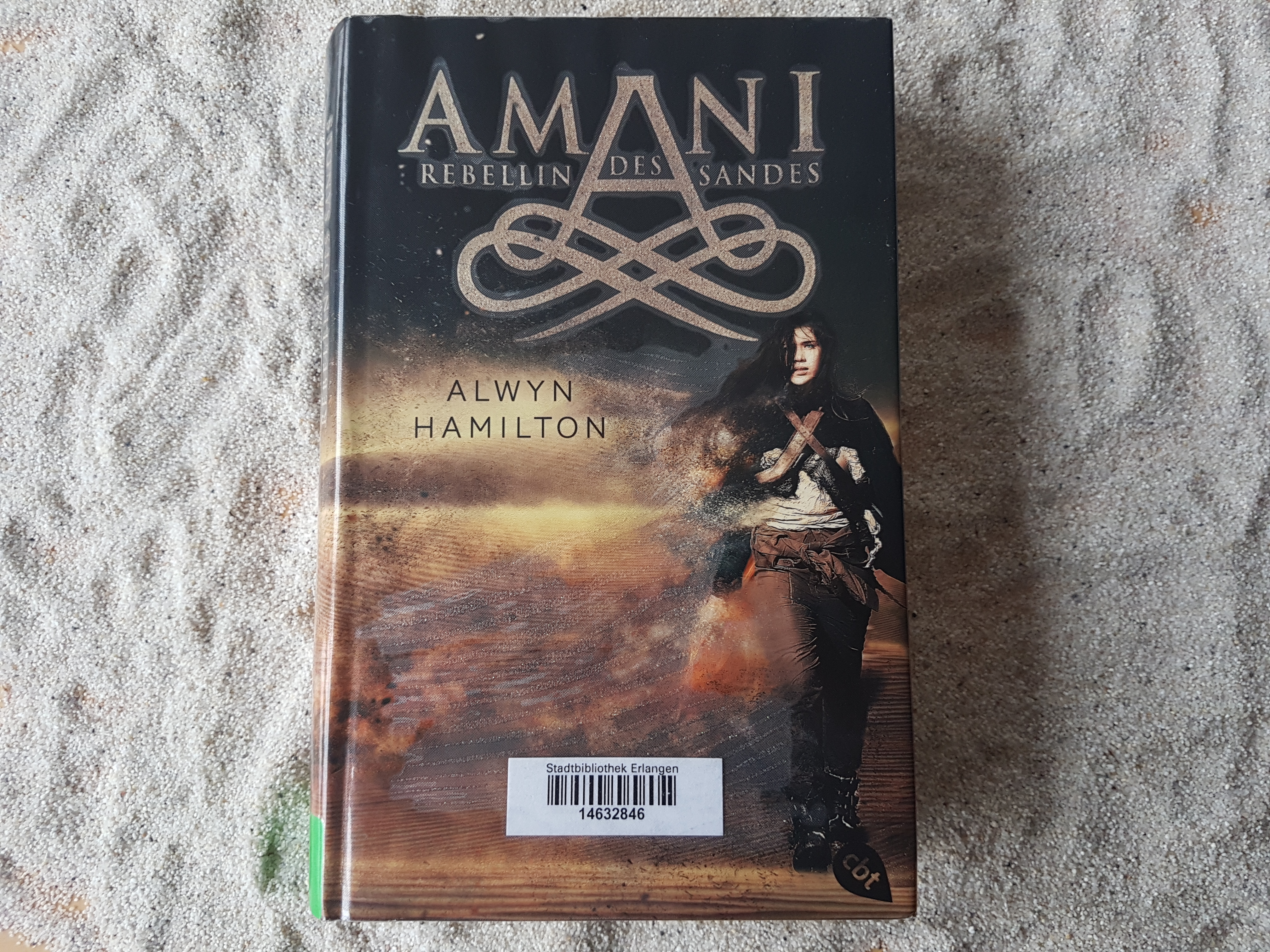 Das Buch "Amani - Rebellin des Sandes" liegt im Sand.