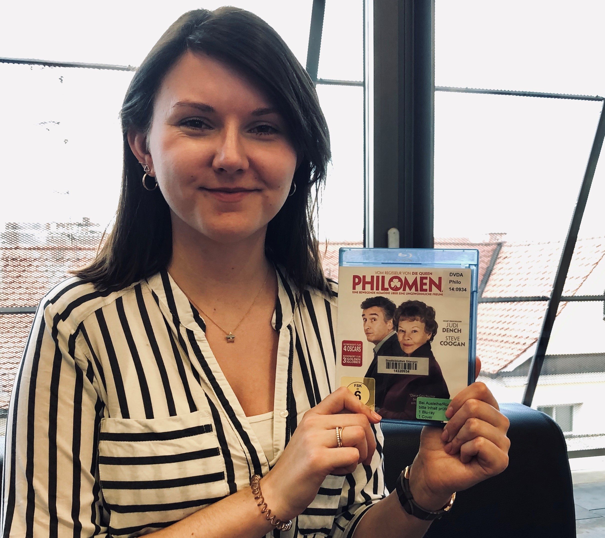 Mitarbeiterin zeigt die DVD Philomena mit Judi Dench