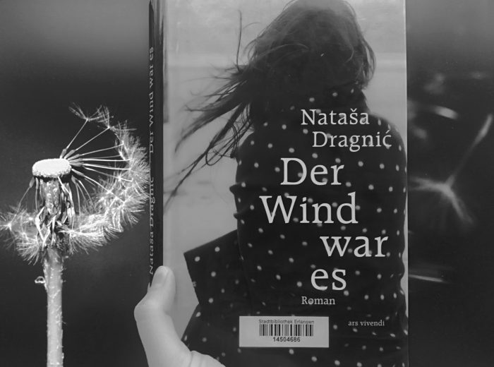 Der Roman "Der Wind war es" vor einem Foto einer Pusteblume © Stadtbibliothek Erlangen © Stadtbibliothek Erlangen