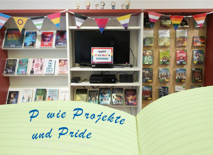 Im Hintergrund ist eine Medienausstellung zum Pride-Month, davor ein aufgeschlagenes Tagebuch mit der Aufschrift "P wie Projekte und Pride". (CC0)
