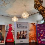 Von Frauen geschriebene Klassiker reihen sich aneinander. Die Bücher "Stolz und Vorurteil", "Jane Eyre", "Little Women", "Vernunft und Gefühl" und "Anne of Green Gables" stehen vor einem barocken Spiegel.