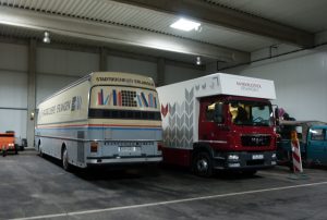 Das Bild zeigt den alten Bücherbus und den neuen LKW der Fahrbibliothek in der Fahrzeughalle des städtischen Betriebshofs.
