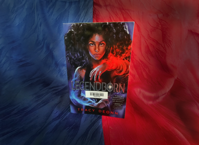 Das Buch "Legendborn" vor einem blau-roten Hintergrund.