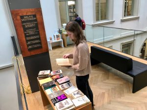 Besucherin schaut sich DDR-Bücher an.