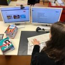 Praktikantin im Büro der Stadtbibliothek Erlangen am Computer mit Büchern