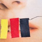 Mund mit drei Zetteln in gelb, rot, schwarz überklebt