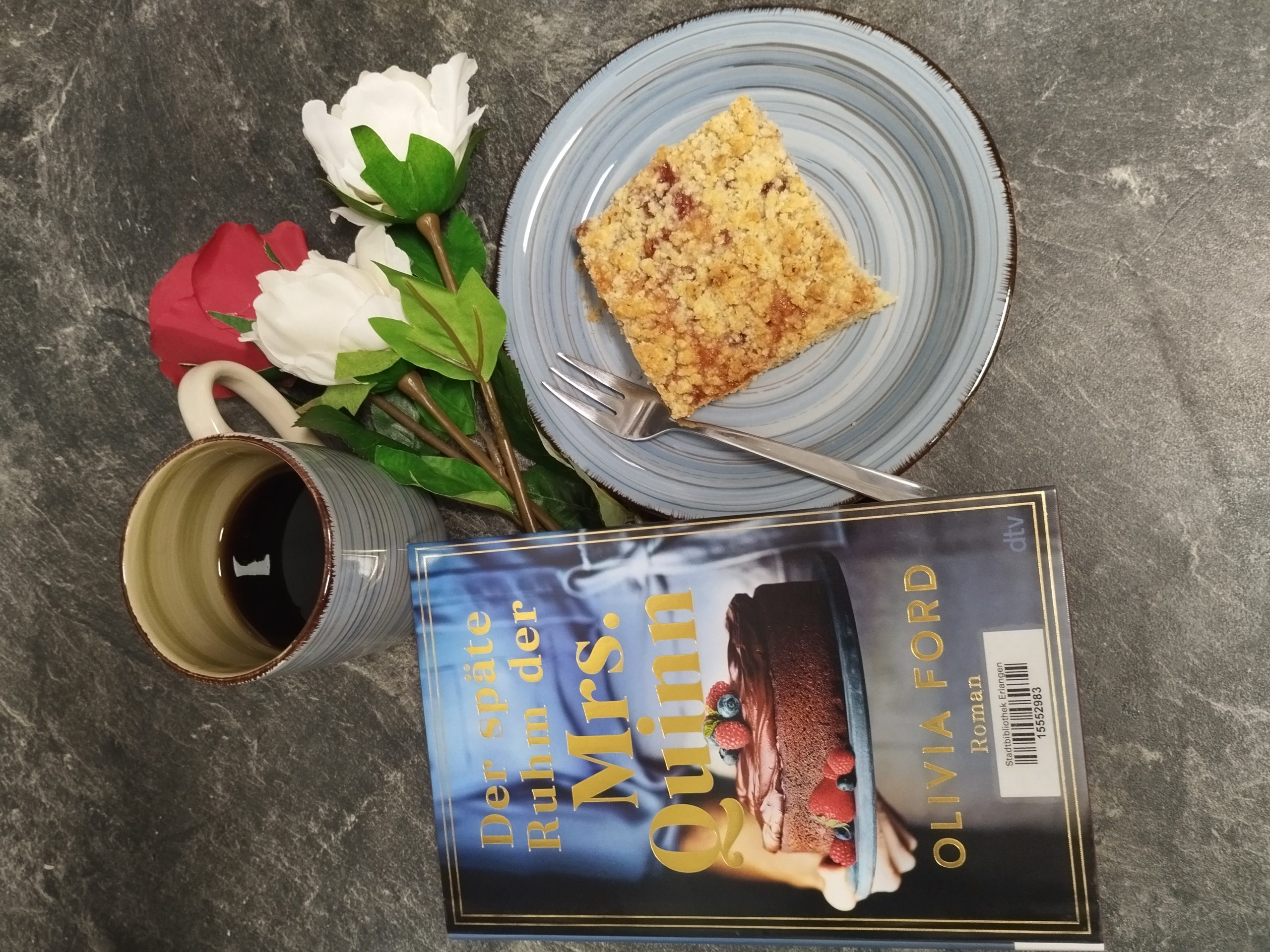 Buch Der späte Ruhm der Mrs. Quinn von Olivia Ford mit Kaffee, Kuchen, Blumen